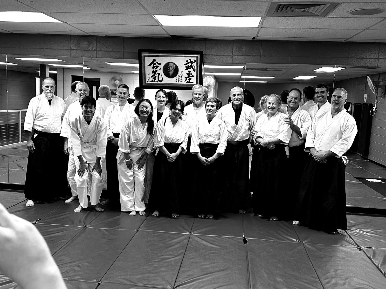 Members of Rocky Mountain Aikikai lined up on the mat in front of the dojo scroll